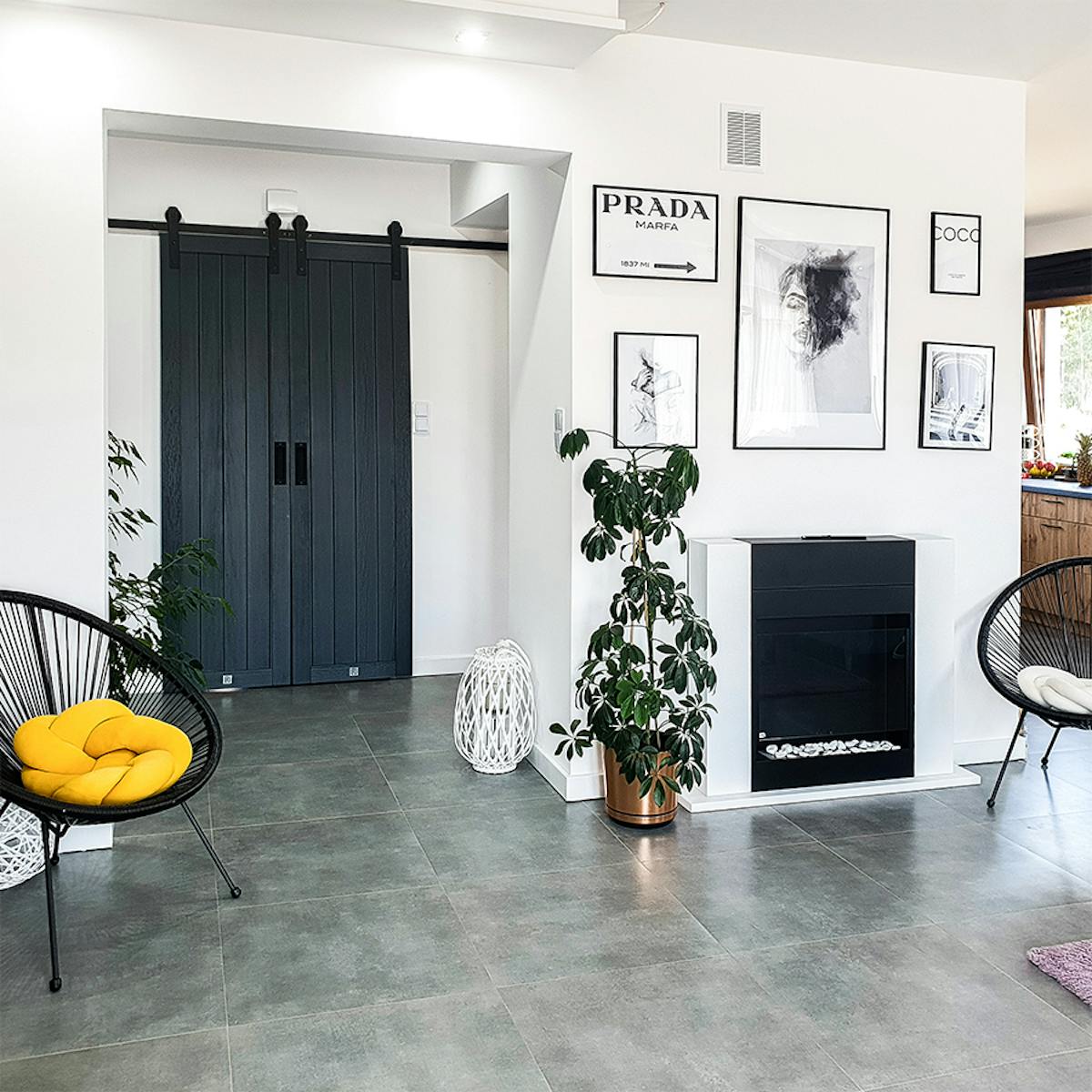 room doors anthracite, anthracite wooden doors, anthracite color doors, double sliding doors, sliding doors in the hall, black accessories in the interior, accessories in anthracite color, photos in a black frame, white and black in a modern home, modern interior, a fireplace in the living room, round openwork armchair