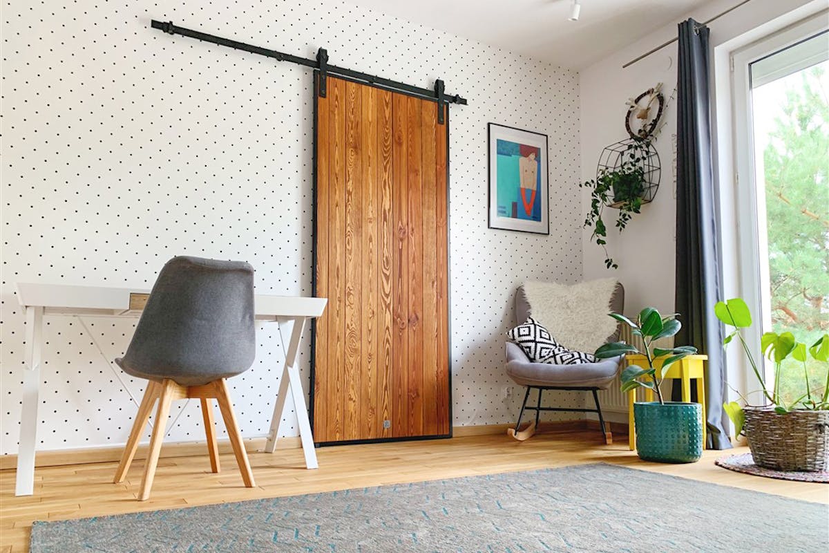 Loft-Tür, Holztür im Metallrahmen, Schiebetür aus Holz und Stahl, Tür aus Kiefern, Schiebetür im Schlafzimmer, Holztür, gepunktete Tapeten, Idee für Tapeten im Schlafzimmer, Schranktür, Accessoires im skandinavischen Stil, Schaukelstuhl im Schlafzimmer, geometrische Muster im Schlafzimmer, weiße Tisch, kleine gelbe Schlafzimmertisch