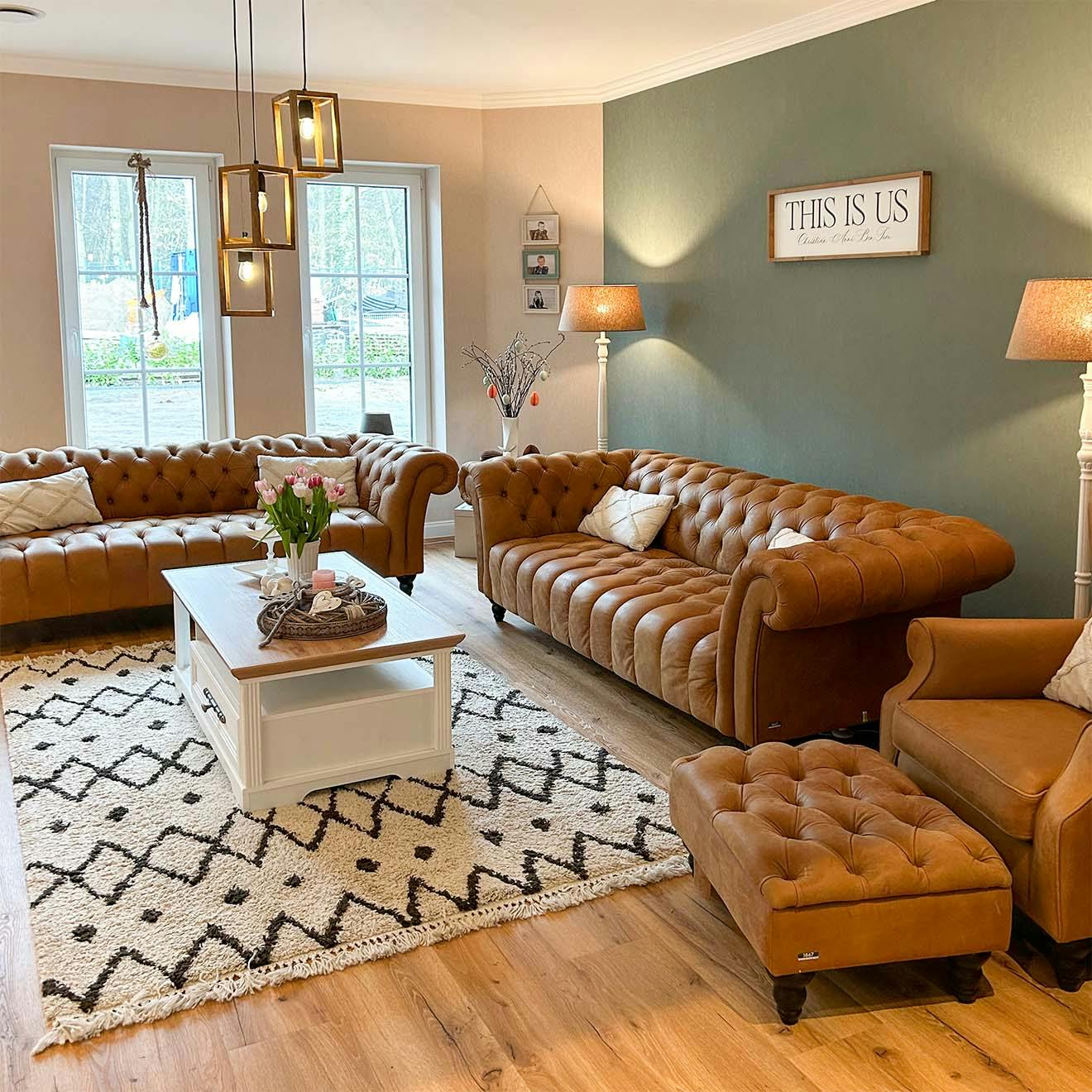 brown quilted sofas and armchairs and a white wooden coffee table in a classic living room arrangement