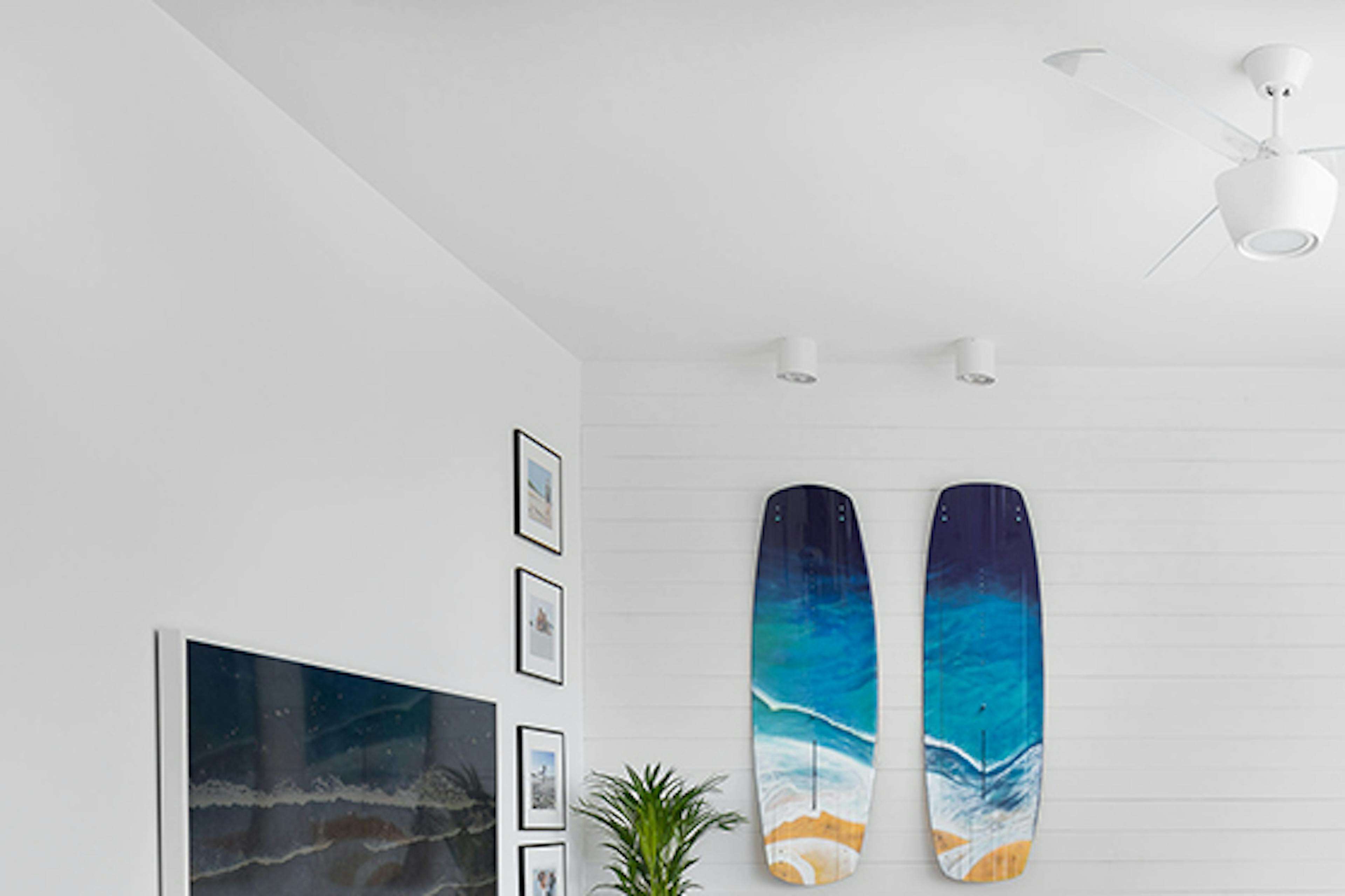 Un salon spacieux et lumineux avec un grand canapé lumineux, décoré dans le style côtier californien avec du bois et du blanc