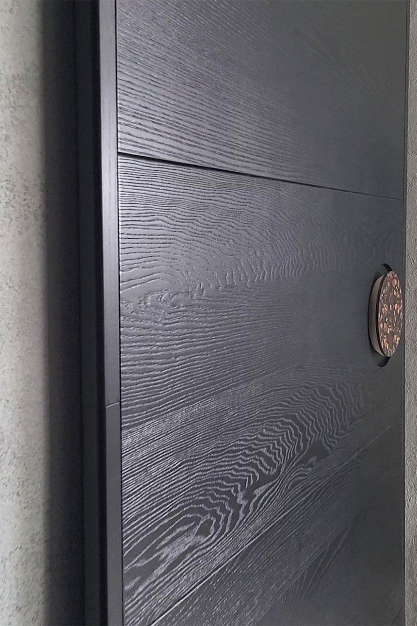 czarne drewniane drzwi przesuwne z okrągłą klamką