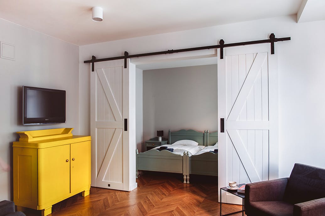 une commode jaune à côté des doubles portes coulissantes blanches